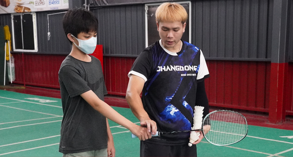 羽球教練指導孩子練習握羽球拍技巧