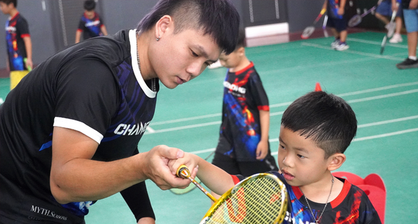 羽球教練在寒假育樂營中帶小朋友練習揮拍