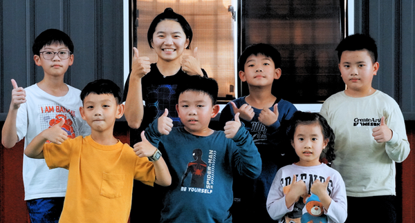 羽球教練帶著育樂營班的小朋友。